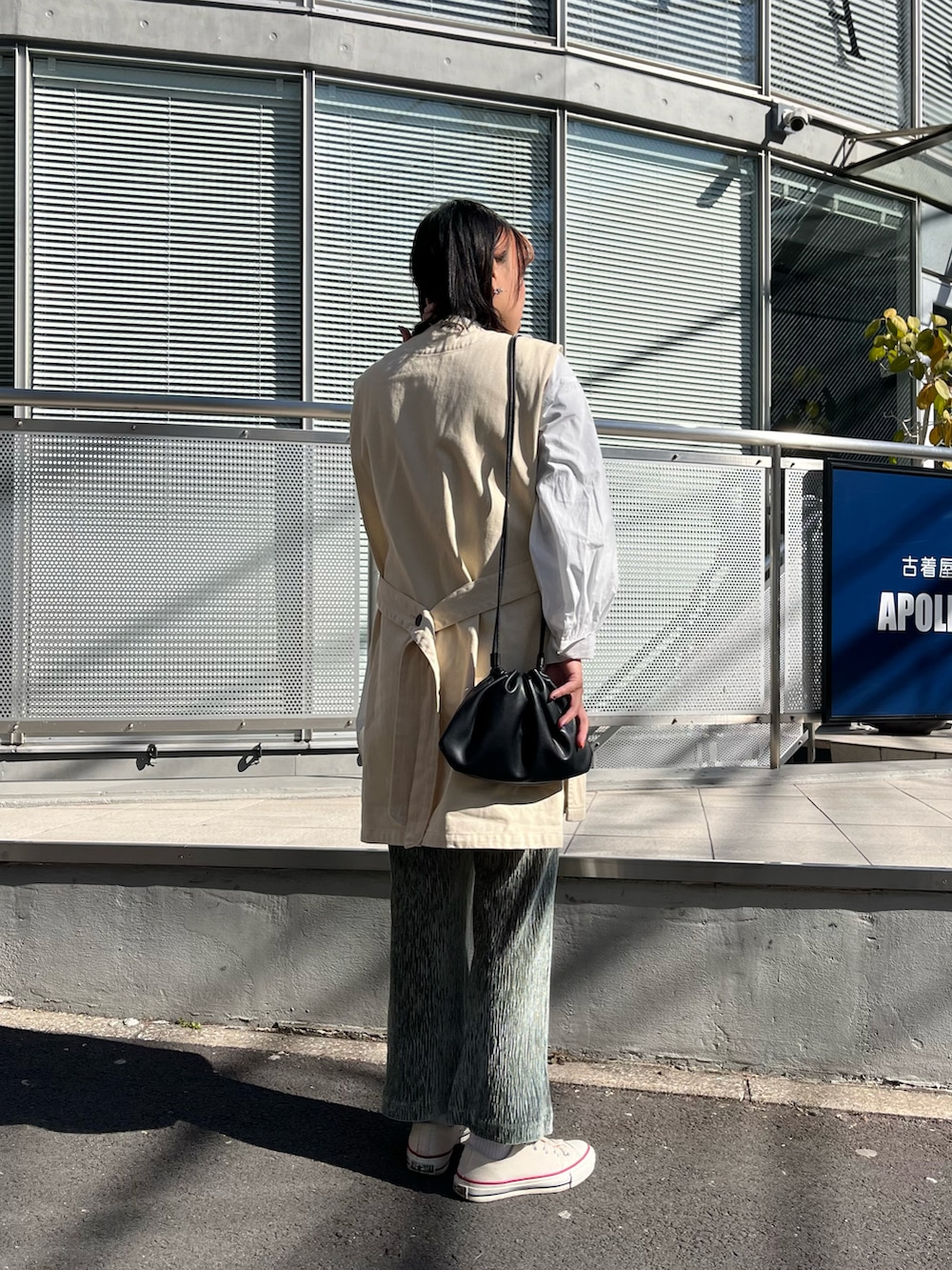 ブラック系のショルダーバッグ、ホワイト系のベスト、ホワイト系のシャツ/ブラウスを着用したレディースの冬コーディネートの2枚目の写真