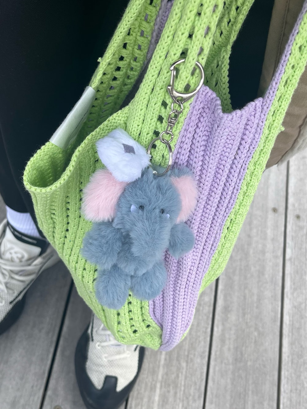 グリーン系のハンドバッグ、シルバー系の財布、イエロー系のポーチを着用したレディースの春コーディネートの2枚目の写真