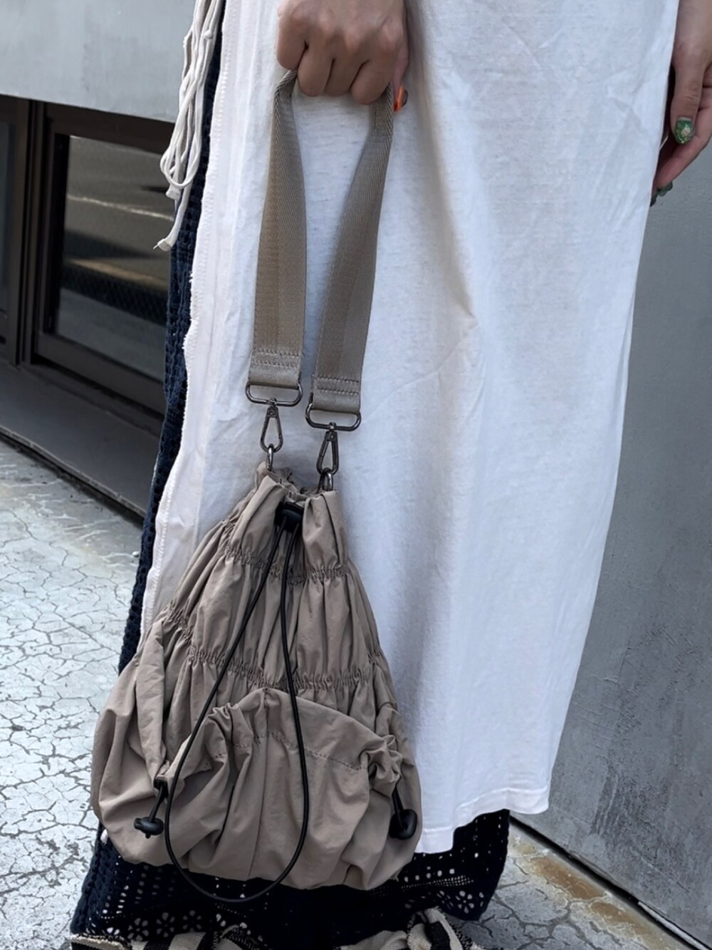 ホワイト系のトップス、ブルー系のパンツ、ホワイト系のシューズを着用したレディースの夏コーディネートの2枚目の写真