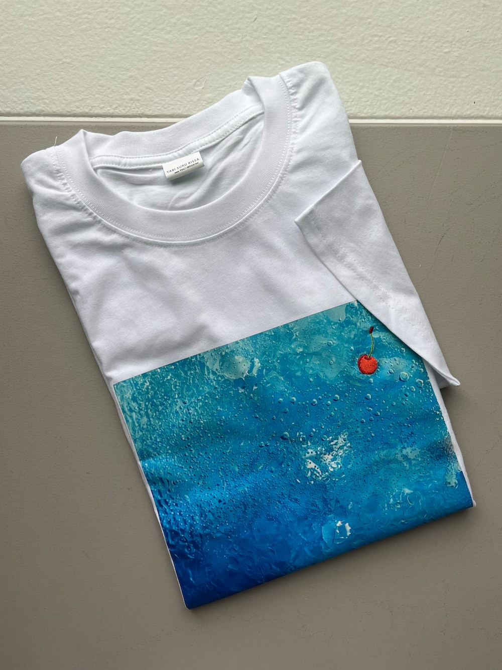 ブルー系のTシャツ/カットソー、ピンク系のトートバッグ、パープル系の折りたたみ傘を着用したレディースの夏コーディネートの3枚目の写真