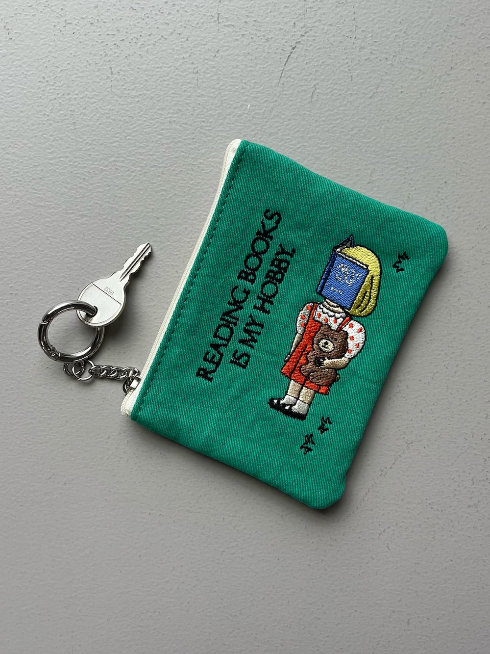 ピンク系のエコバッグ/サブバッグ、グリーン系のポーチ、ベージュ系のチャームを着用したレディースの夏コーディネートの3枚目の写真