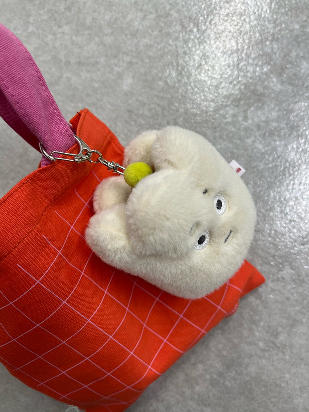 レッド系のポーチ、イエロー系のポーチ、ホワイト系のチャームを着用したレディースの冬コーディネートの3枚目の写真