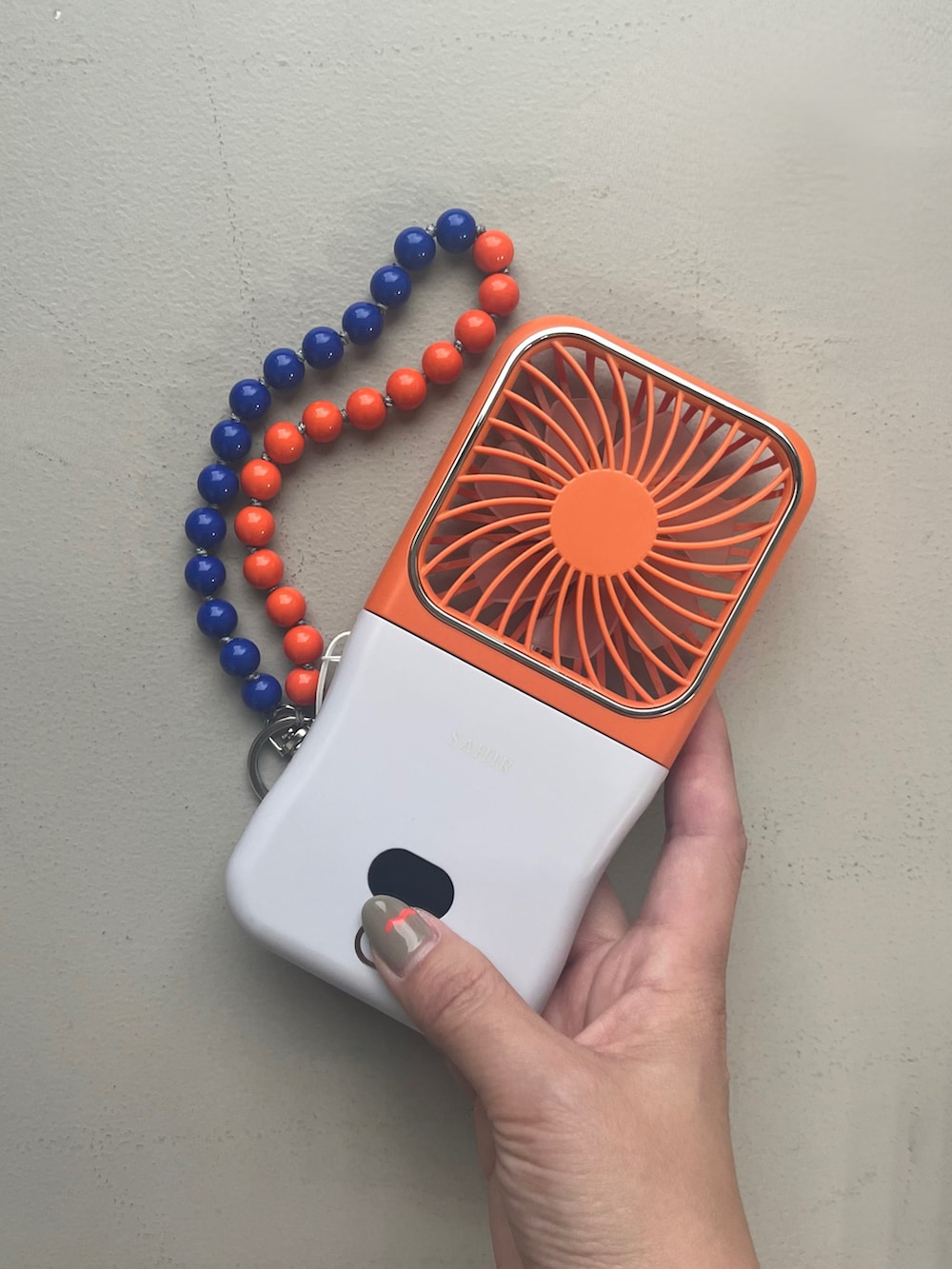 ホワイト系のポーチ、イエロー系の財布、オレンジ系のチャームを着用したレディースの春コーディネートの4枚目の写真