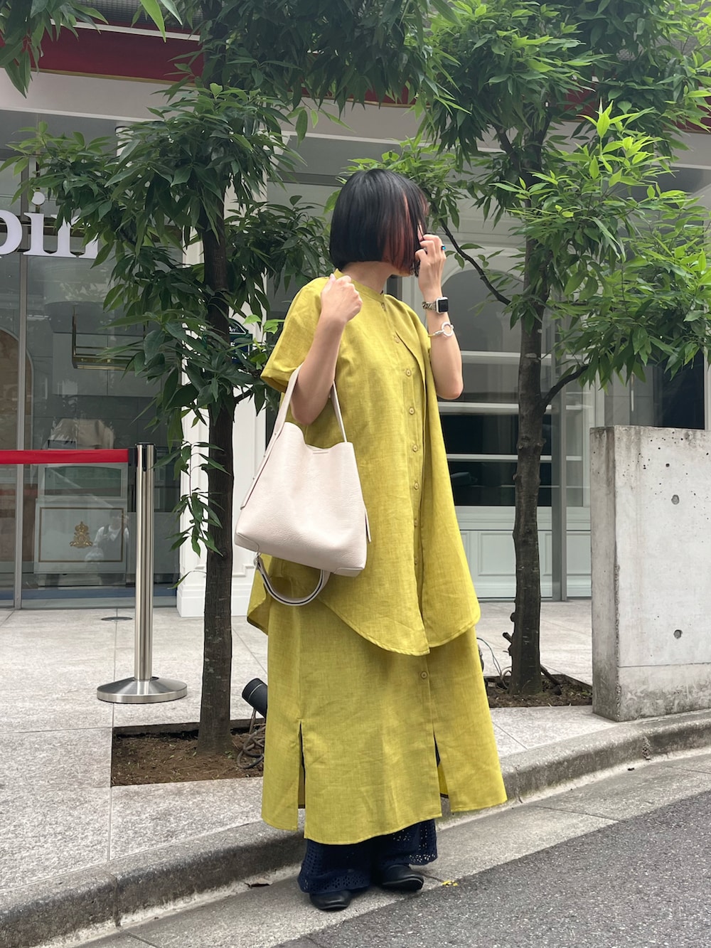 ブラック系のドレスシューズ、ホワイト系のショルダーバッグ、イエロー系のワンピース/ドレスを着用したレディースの夏コーディネートの2枚目の写真