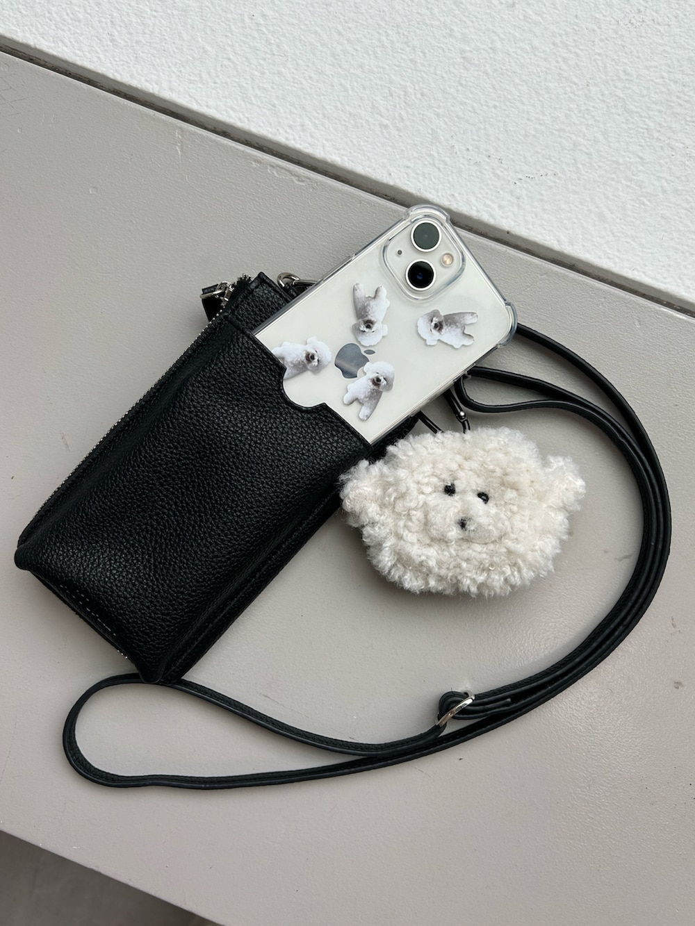 ブラック系のショルダーバッグ、ホワイト系のスマホグッズ、ホワイト系のスマホケース/カバーを着用したレディースの夏コーディネートの2枚目の写真