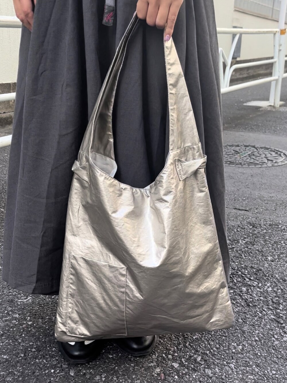 ゴールド系のトートバッグ、ホワイト系のスニーカー、グリーン系のシャツ/ブラウスを着用したレディースの秋コーディネートの2枚目の写真