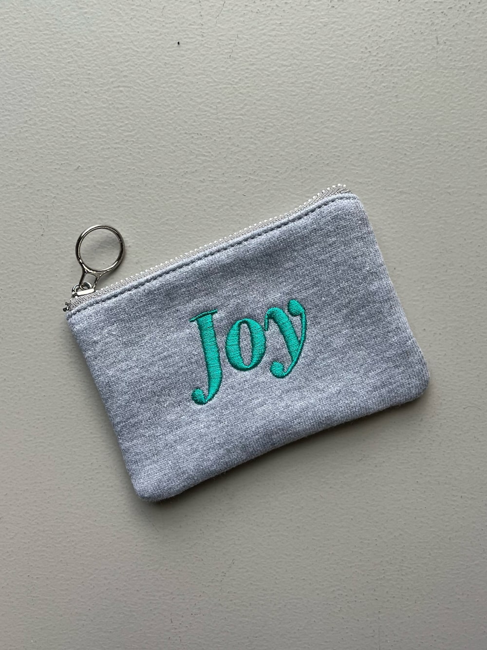 グリーン系のポーチ、シルバー系の財布、グレー系のポーチを着用したレディースの秋コーディネートの5枚目の写真