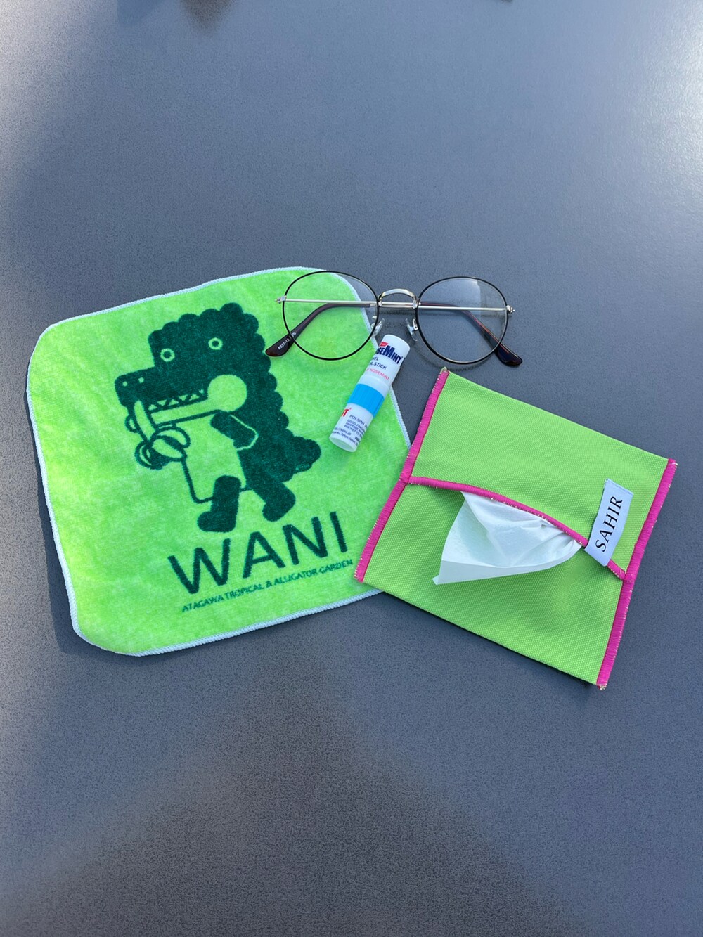 グレー系のヘッドフォン/イヤホン、グリーン系のポーチ、シルバー系の財布を着用したレディースの春コーディネートの2枚目の写真