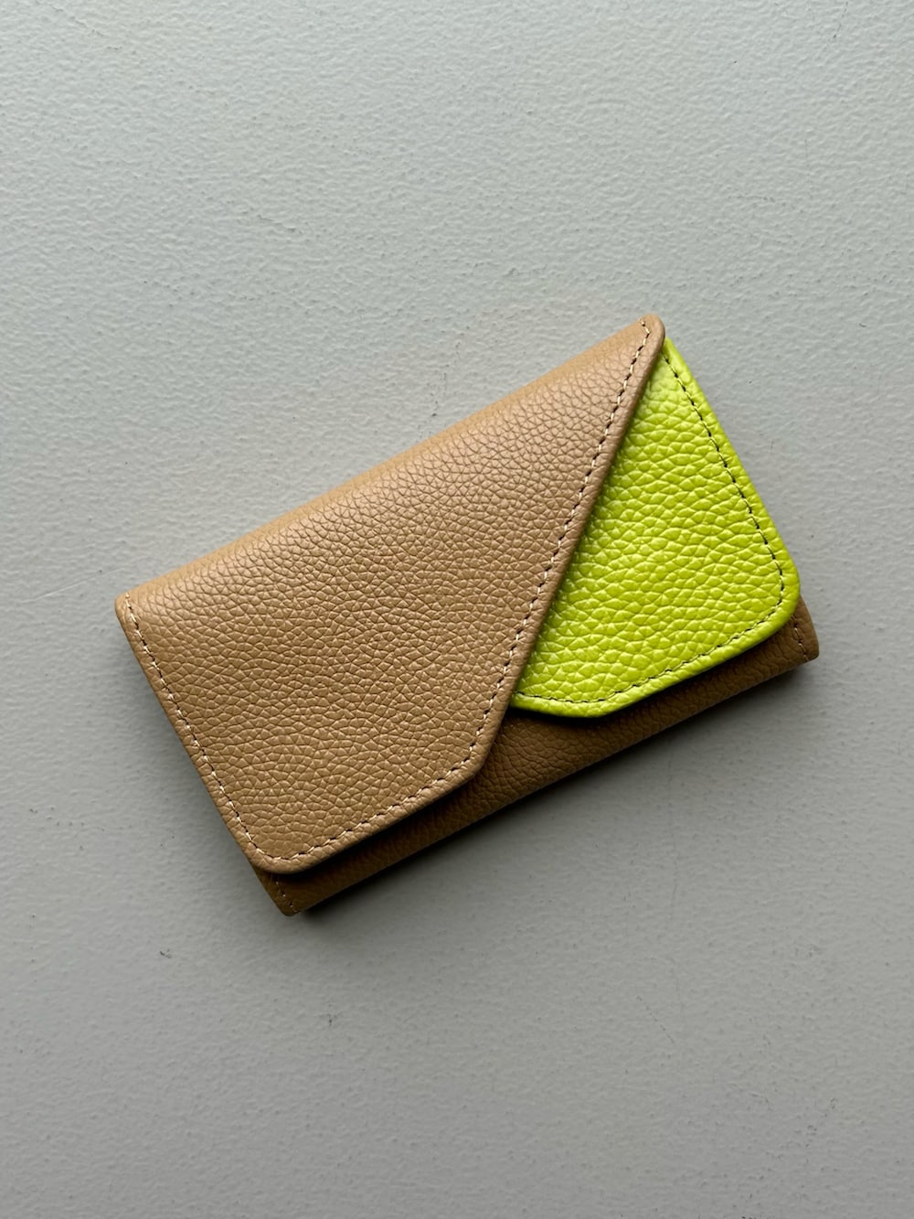 ブルー系のポーチ、ベージュ系の名刺入れ、ホワイト系のチャームを着用したレディースの春コーディネートの5枚目の写真