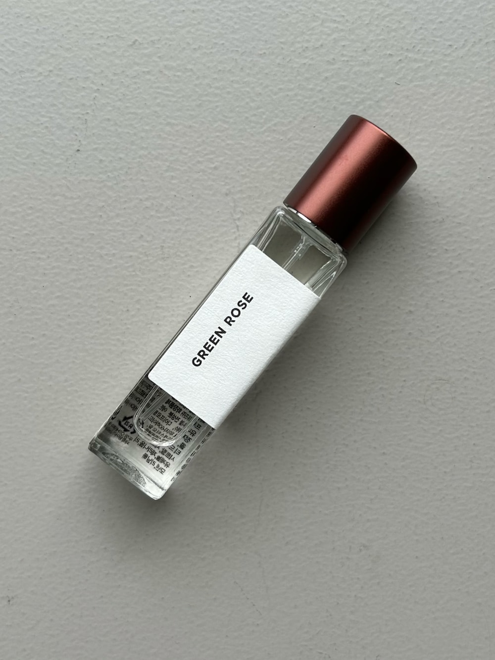 グリーン系の財布、グレー系のポーチ、ホワイト系のチャームを着用したレディースの春コーディネートの4枚目の写真