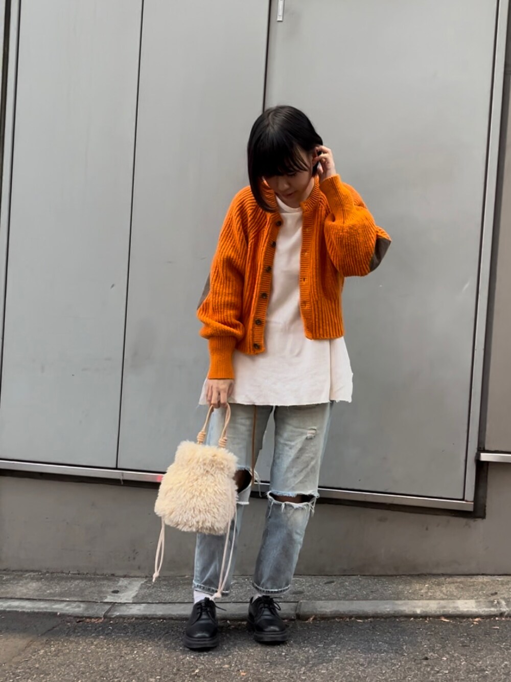 ホワイト系のトートバッグ、オレンジ系のニット/セーター、ブラック系のローファーを着用したレディースの秋コーディネートの2枚目の写真