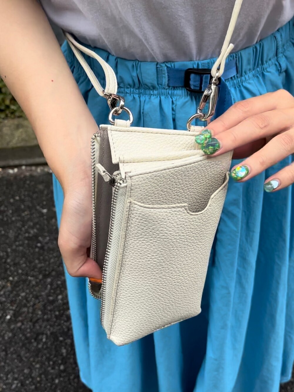 ブルー系のスカート、ホワイト系のTシャツ/カットソー、ホワイト系のショルダーバッグを着用したレディースの夏コーディネートの2枚目の写真