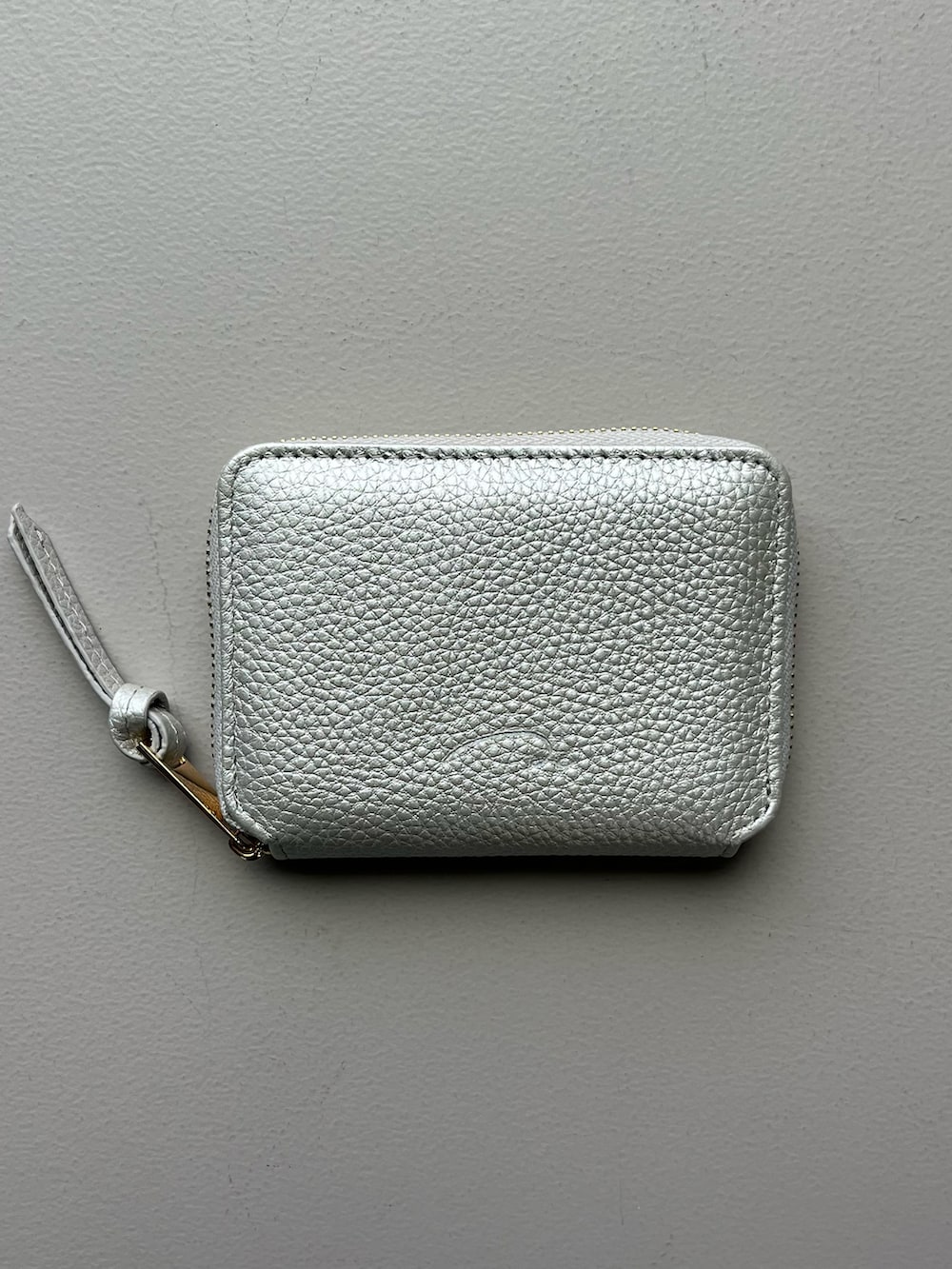 グリーン系のスマホグッズ、シルバー系のポーチ、ホワイト系のその他小物を着用したレディースの秋コーディネートの4枚目の写真