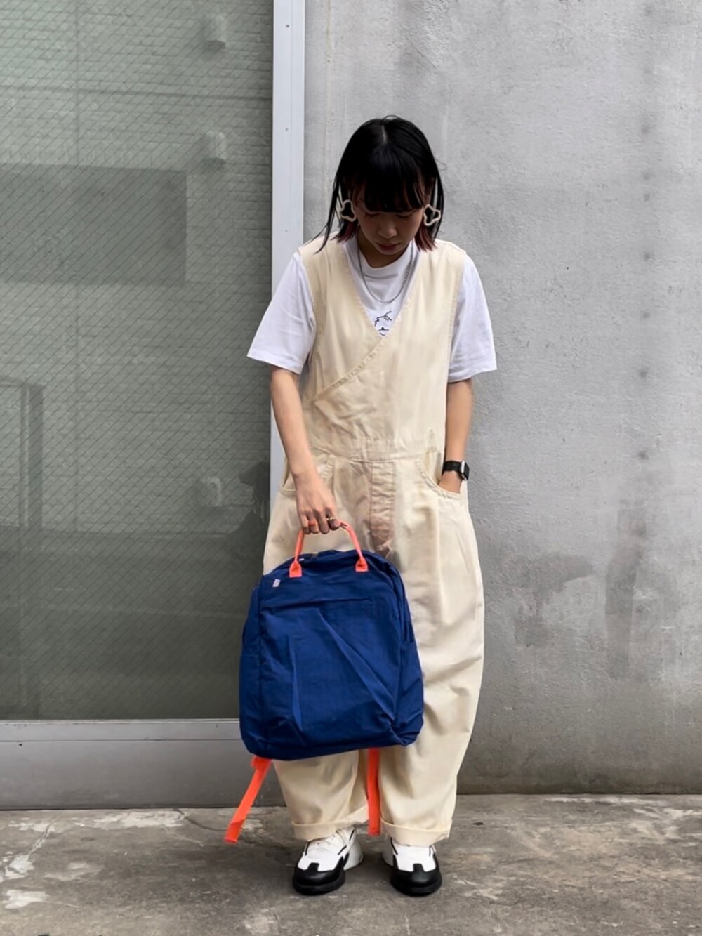 ブルー系のバックパック/リュック、ホワイト系のスニーカー、ベージュ系のサロペット/オーバーオールを着用したレディースの夏コーディネートの2枚目の写真