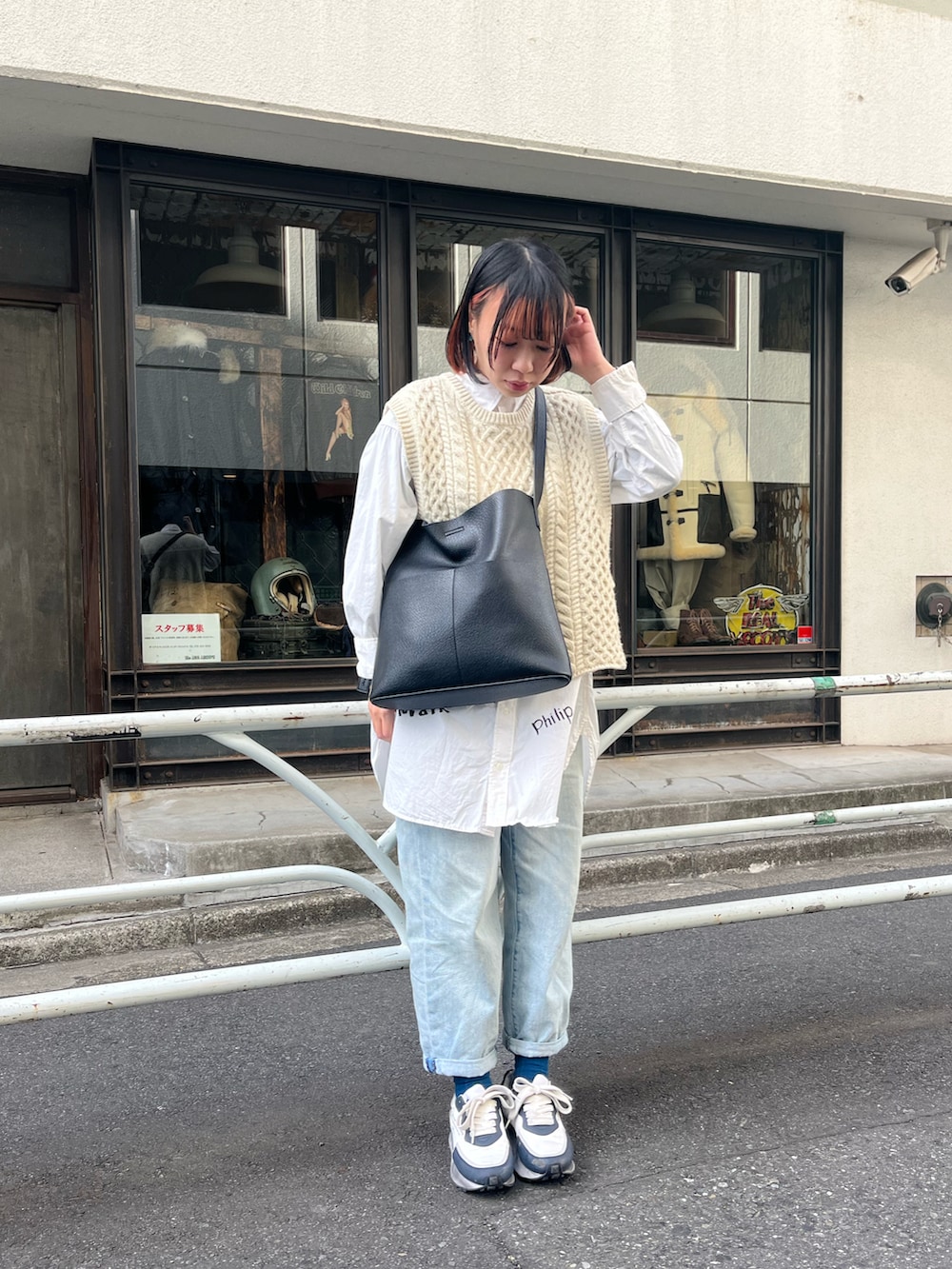 ブラック系のショルダーバッグ、ホワイト系のワンピース、ホワイト系のベストを着用したレディースの冬コーディネートの2枚目の写真