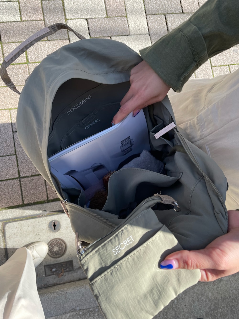 ホワイト系のスニーカー、グリーン系のバックパック/リュックを着用したレディースの春コーディネートの3枚目の写真