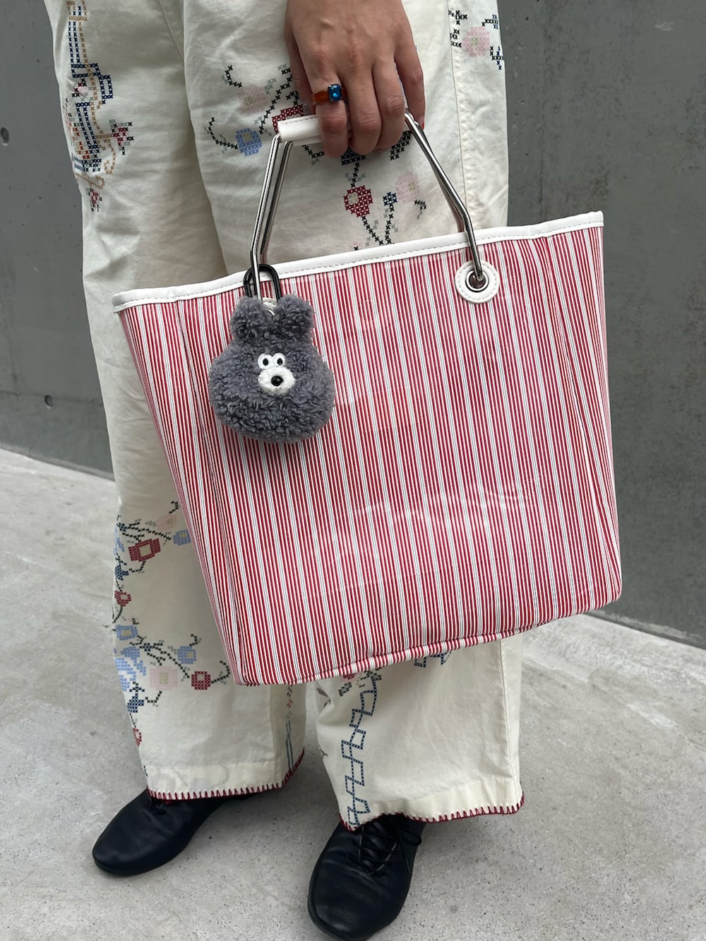 オレンジ系のトートバッグ、ホワイト系のその他パンツ、ブラック系のドレスシューズを着用したレディースの夏コーディネートの2枚目の写真