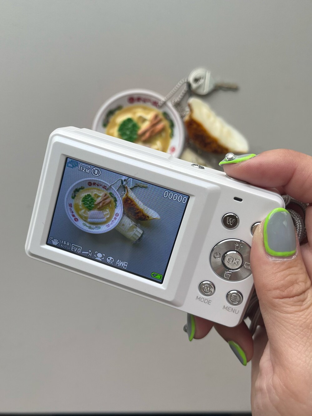 ホワイト系のポーチ、グリーン系の生活家電、イエロー系のパスケースを着用したレディースの春コーディネートの3枚目の写真