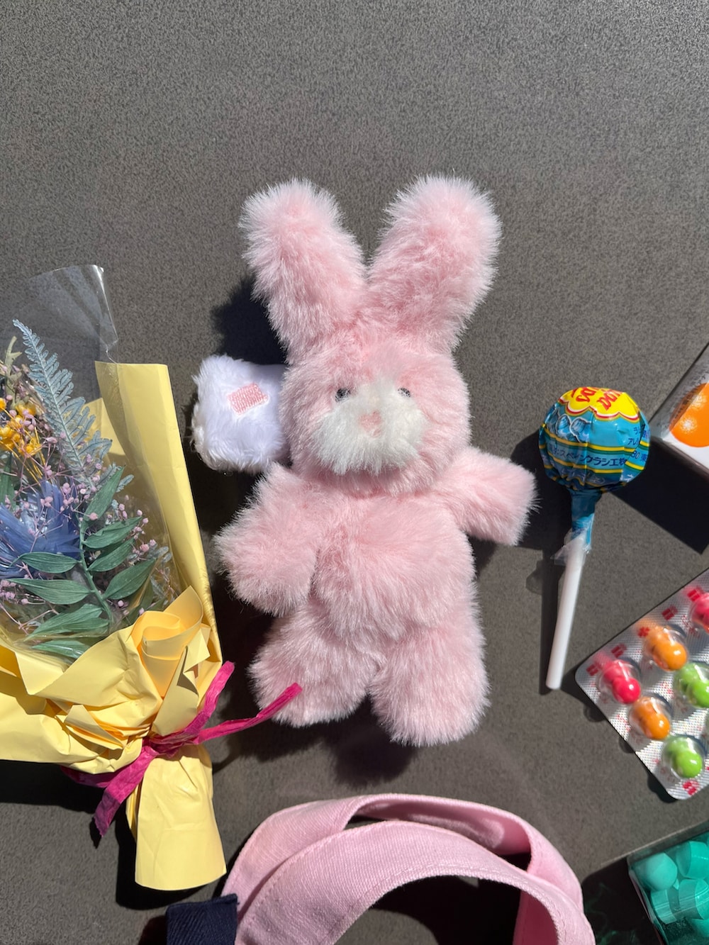 オレンジ系のトートバッグ、ピンク系のチャームを着用したレディースの春コーディネートの2枚目の写真