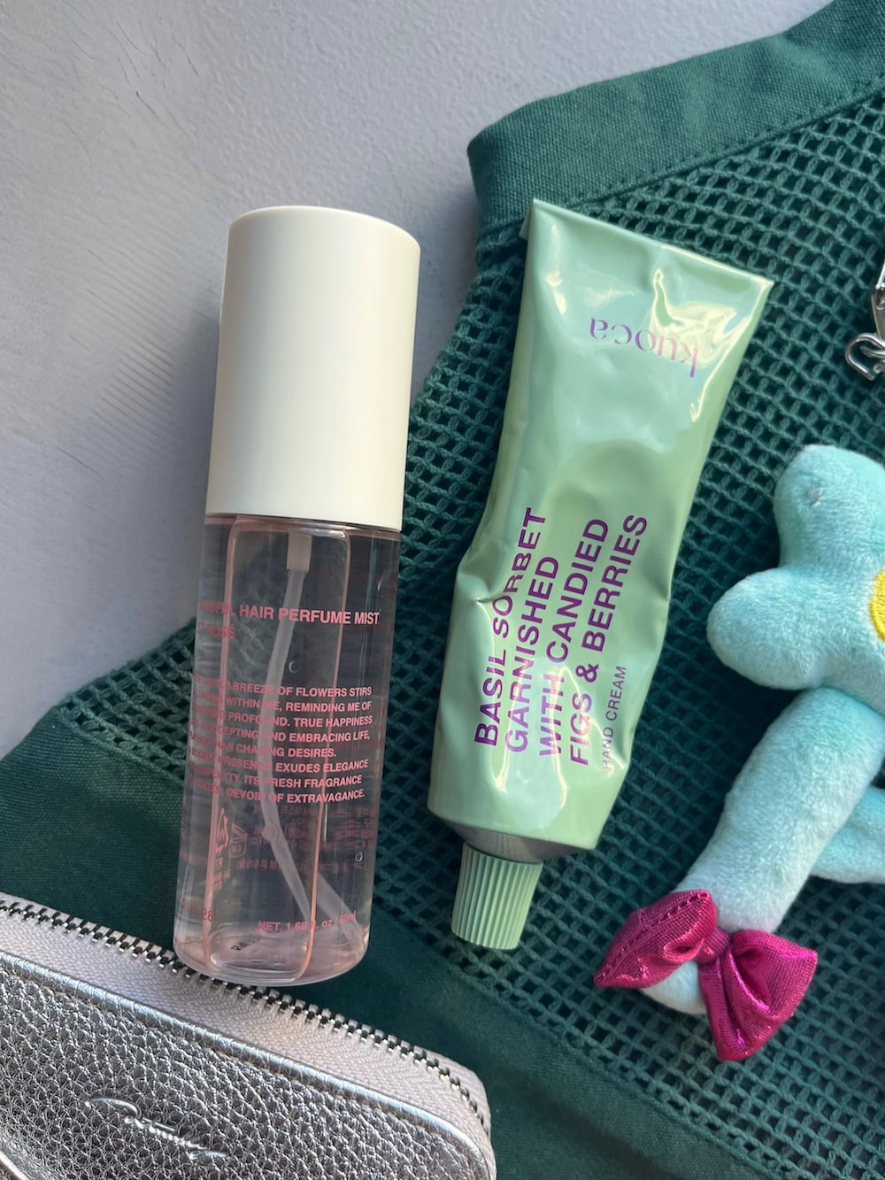 シルバー系の財布、オレンジ系のポーチ、ブルー系のキーホルダーを着用したレディースの春コーディネートの3枚目の写真