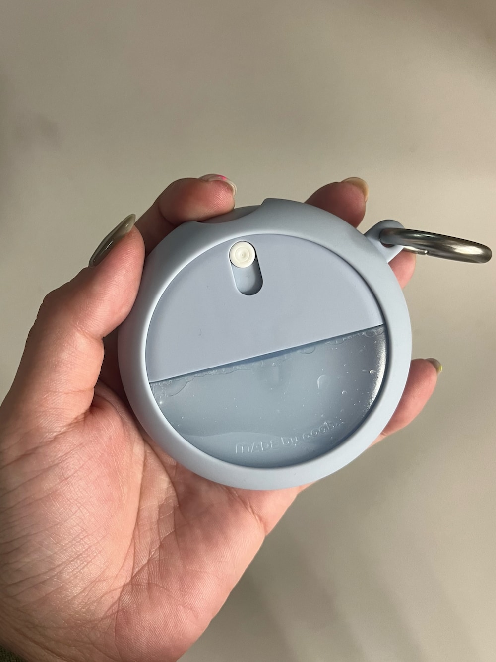 ブルー系のヘアオイル/ヘアミルク、シルバー系の財布、オレンジ系のチャームを着用したレディースの春コーディネートの2枚目の写真