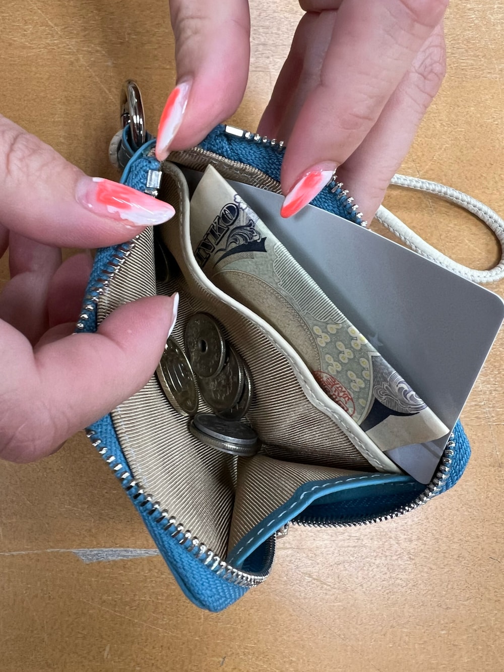 ブルー系の財布、ブラック系のスマホグッズ、ピンク系の財布を着用したレディースの春コーディネートの2枚目の写真