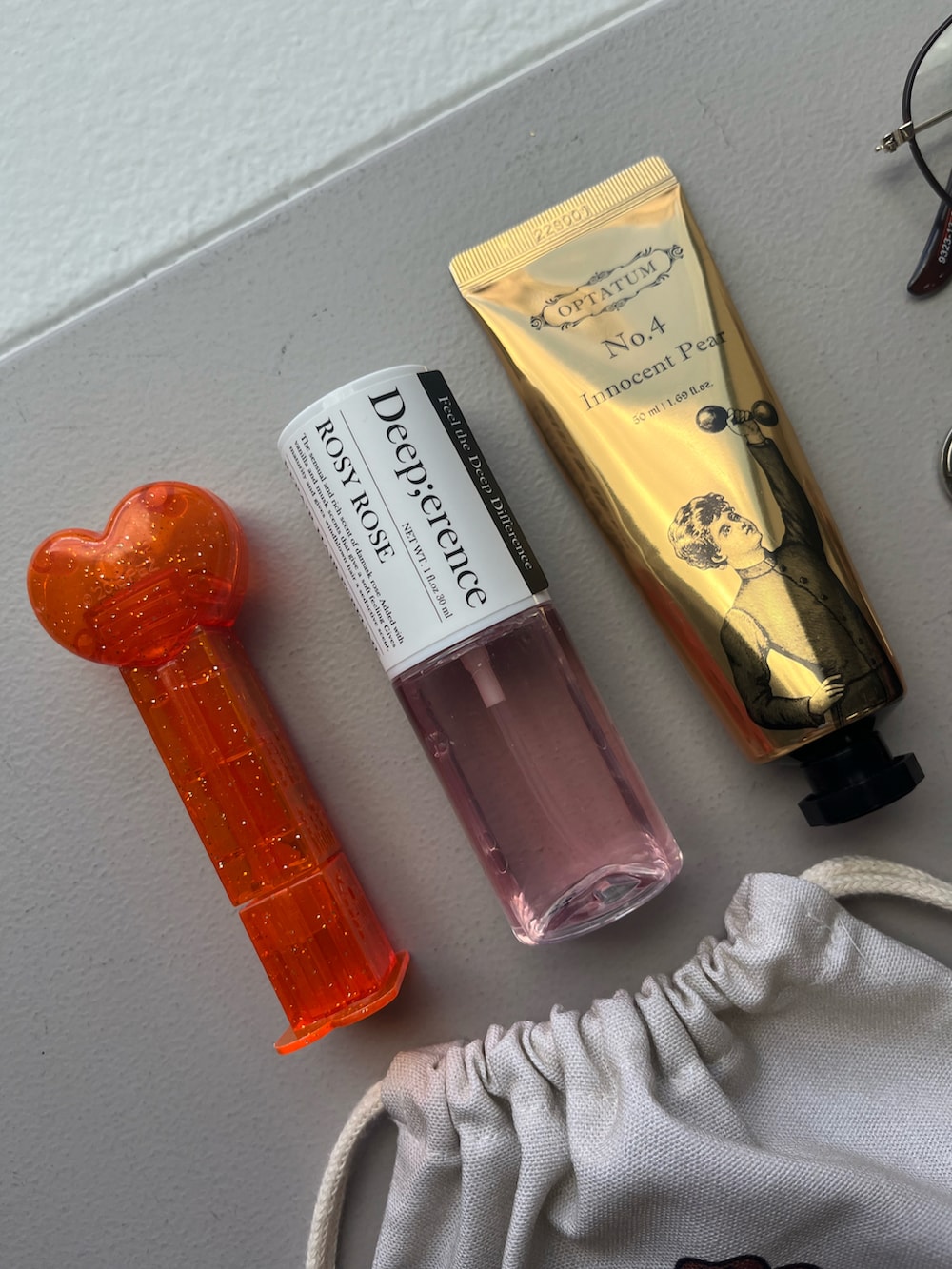 その他のハンドケア/ハンドクリーム、ゴールド系のパスケース、ホワイト系のチャームを着用したレディースの秋コーディネートの5枚目の写真