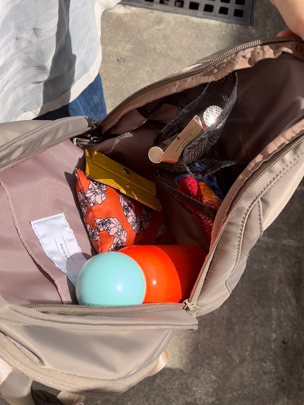 ベージュ系のバックパック/リュック、ホワイト系のスニーカー、ブルー系のデニムパンツを着用したレディースの夏コーディネートの2枚目の写真