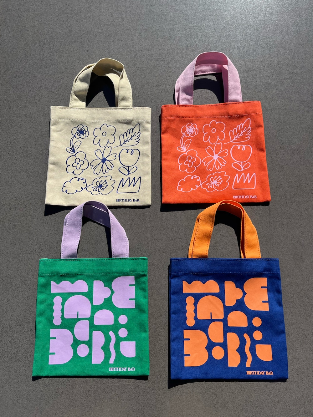 オレンジ系のトートバッグ、ピンク系のチャームを着用したレディースの春コーディネートの3枚目の写真