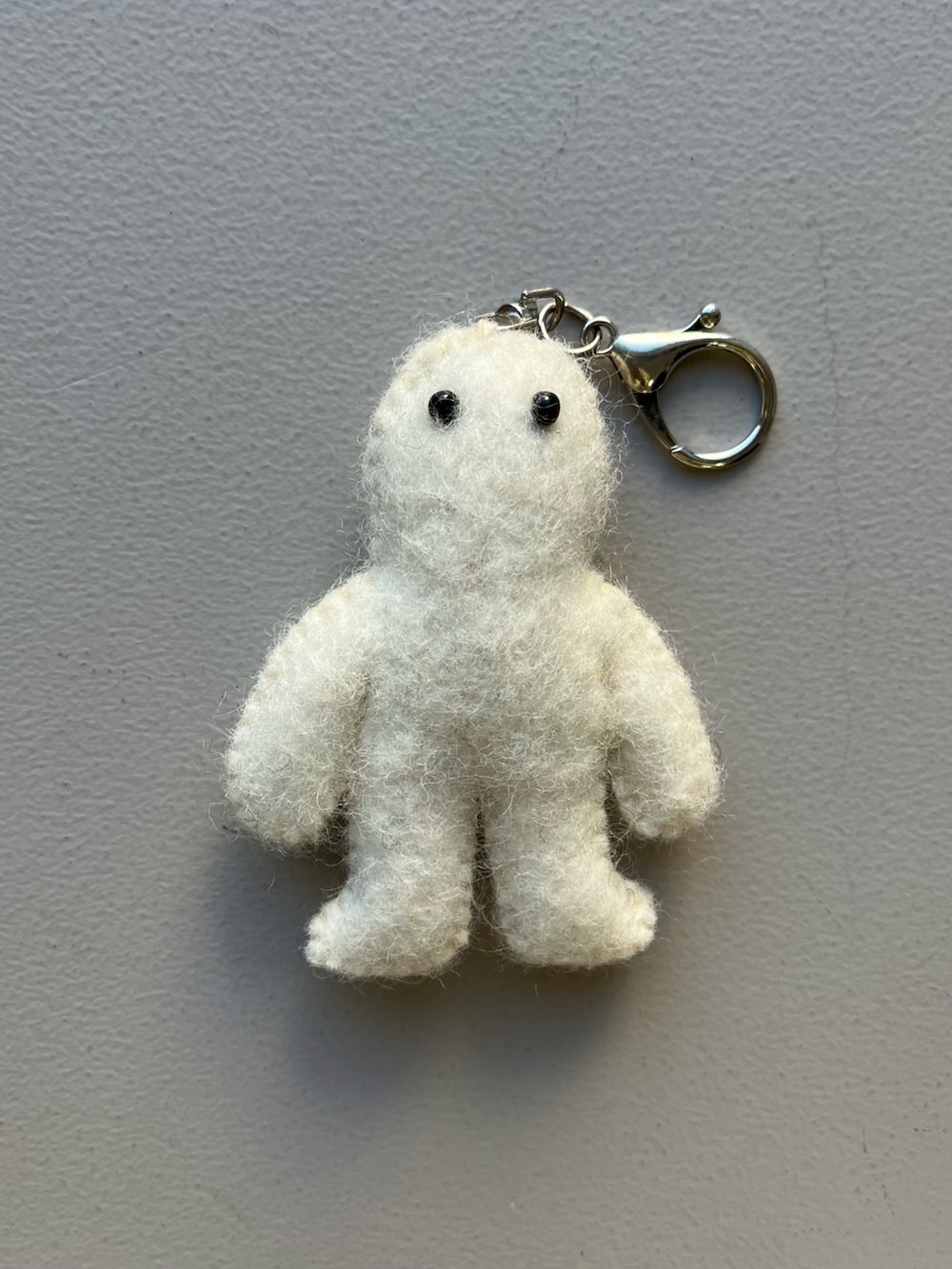 シルバー系の財布、ホワイト系の香水、ブルー系のチャームを着用したレディースの冬コーディネートの3枚目の写真