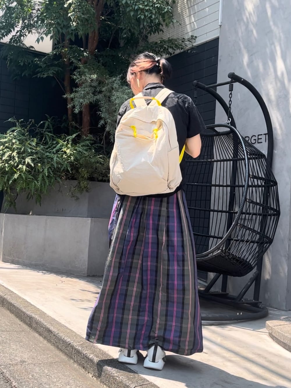 ベージュ系のバックパック/リュック、ホワイト系のスニーカー、ブラック系のシャツ/ブラウスを着用したレディースの夏コーディネートの2枚目の写真