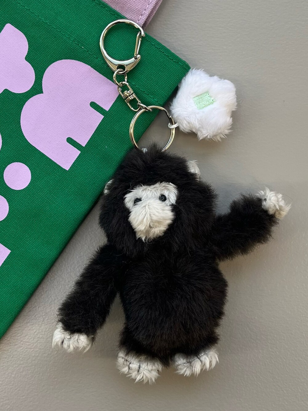 ホワイト系のトートバッグ、ブルー系のチャームを着用したレディースの春コーディネートの5枚目の写真