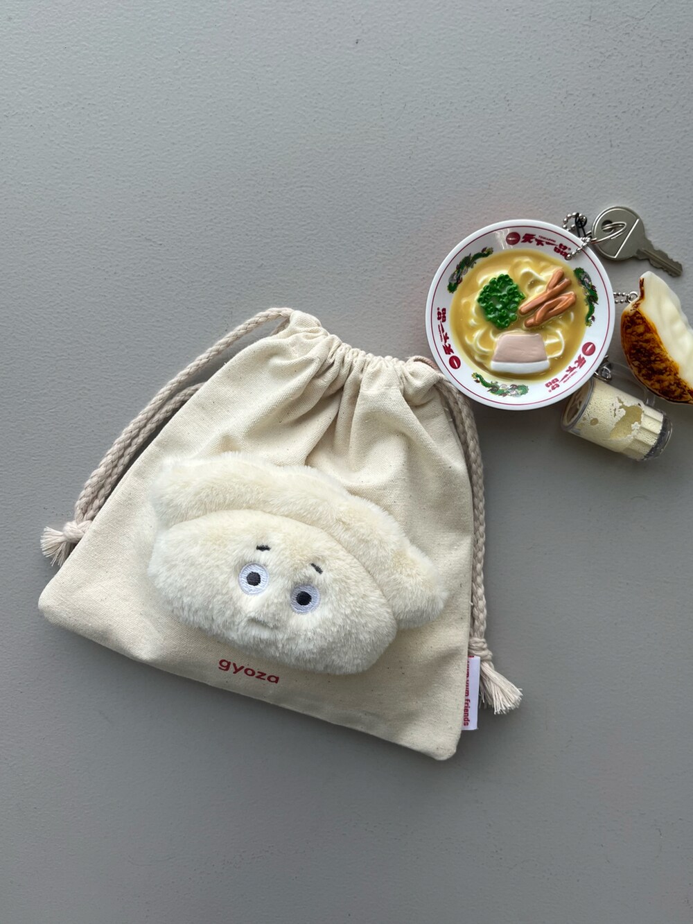 ホワイト系のポーチ、グリーン系の生活家電、イエロー系のパスケースを着用したレディースの春コーディネートの2枚目の写真