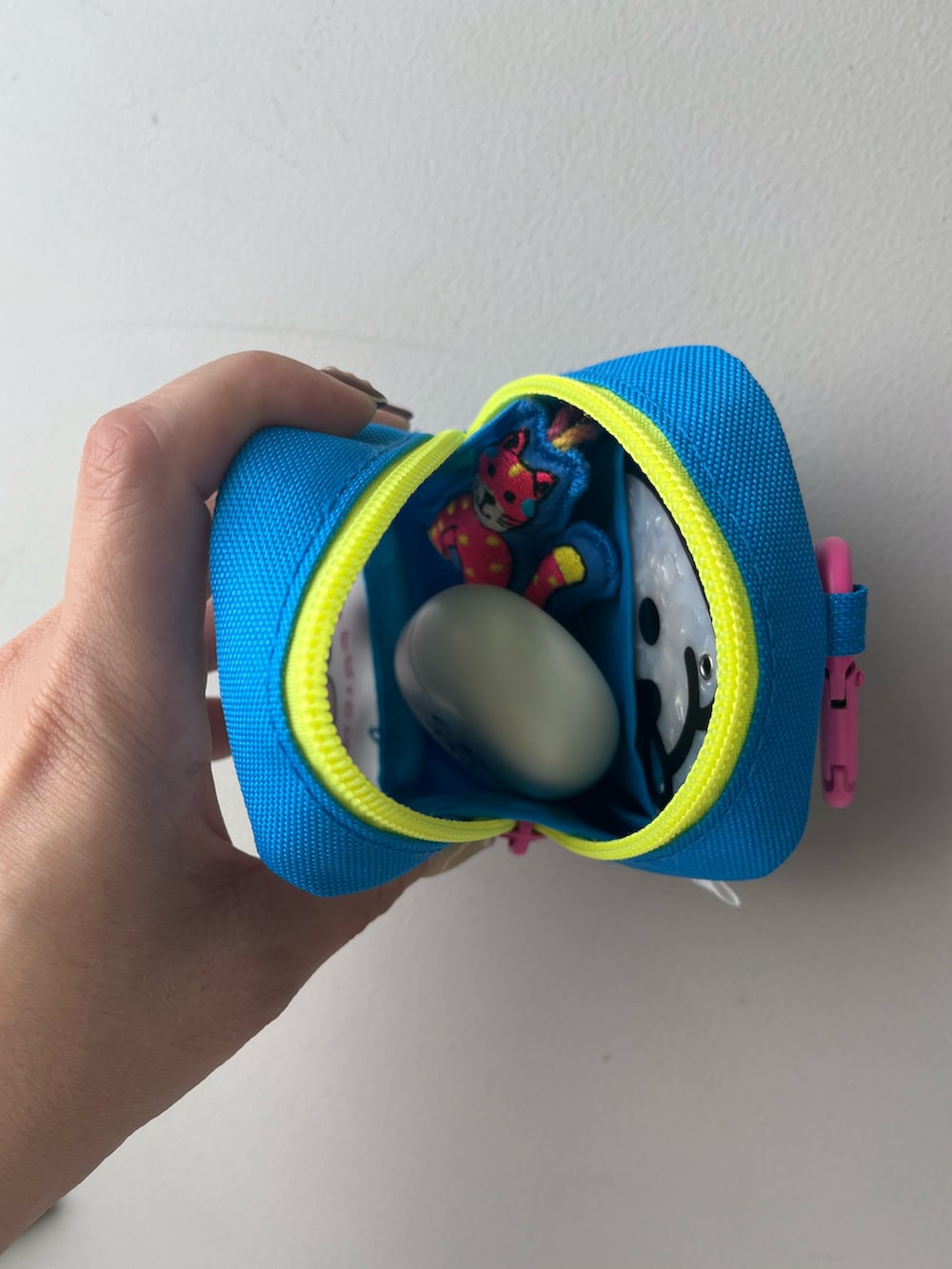 シルバー系の財布、ピンク系のポーチ、ホワイト系の香水を着用したレディースの夏コーディネートの3枚目の写真