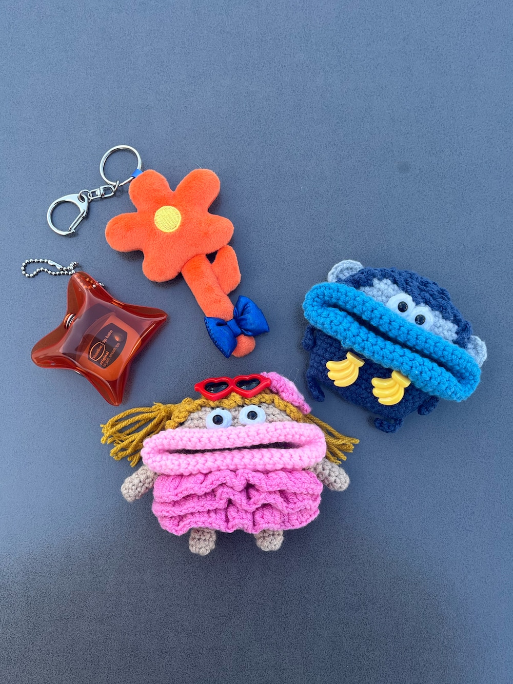 ピンク系のヘッドフォン/イヤホン、シルバー系の財布、オレンジ系のキーホルダーを着用したレディースの春コーディネートの2枚目の写真