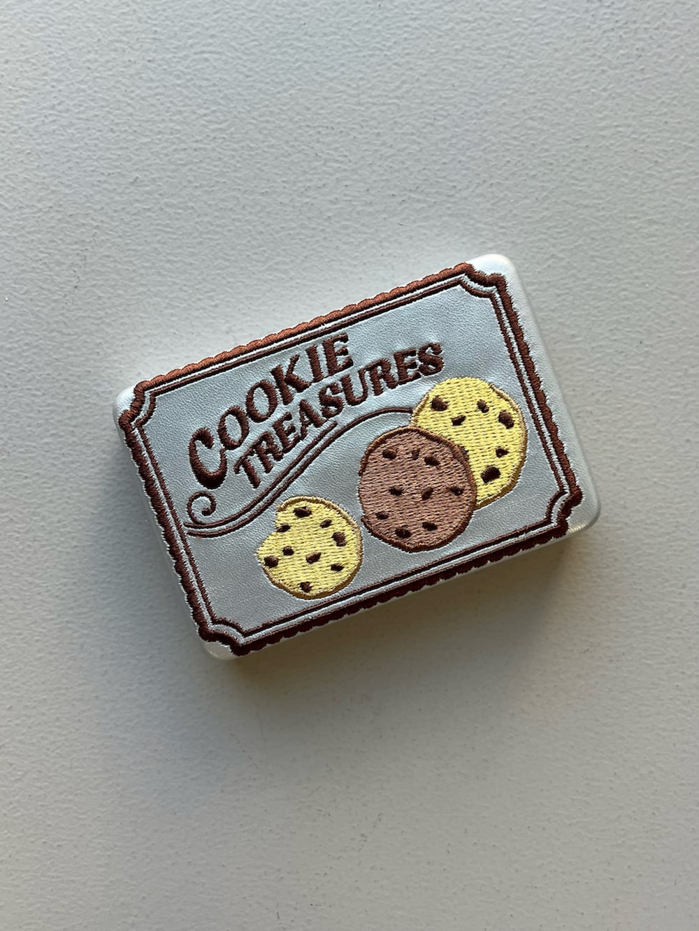 グレー系のポーチ、シルバー系のポーチ、パープル系の香水を着用したレディースの春コーディネートの3枚目の写真