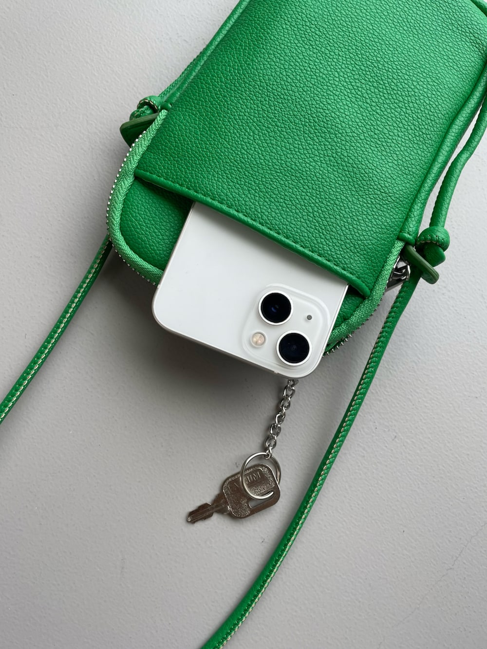 グリーン系のショルダーバッグ、ホワイト系のスニーカー、ベージュ系のニット/セーターを着用したレディースの冬コーディネートの4枚目の写真