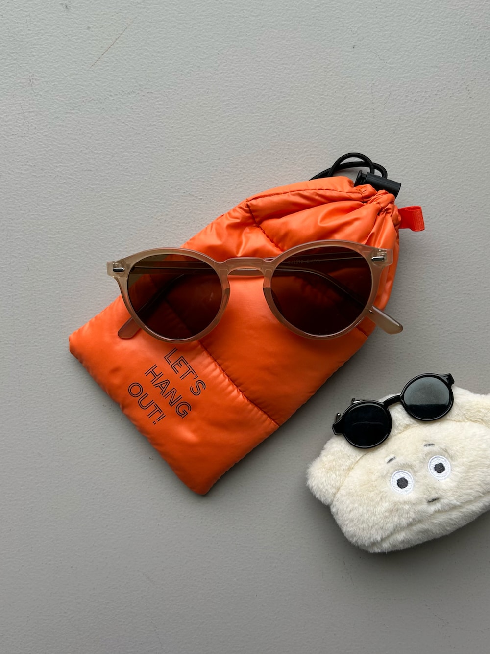 ブルー系のポーチ、ベージュ系の名刺入れ、ホワイト系のチャームを着用したレディースの春コーディネートの4枚目の写真