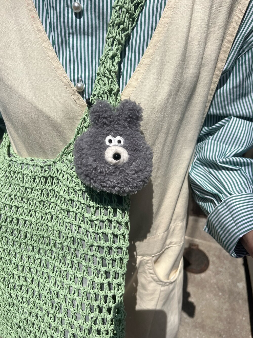 グリーン系のショルダーバッグ、グリーン系のシャツ/ブラウス、グレー系のヘッドフォン/イヤホンを着用したレディースの春コーディネートの4枚目の写真