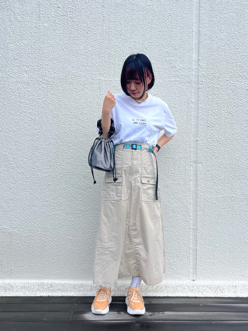 ベージュ系のスニーカー、ベージュ系のスカート、シルバー系のトートバッグを着用したレディースの春コーディネートの2枚目の写真