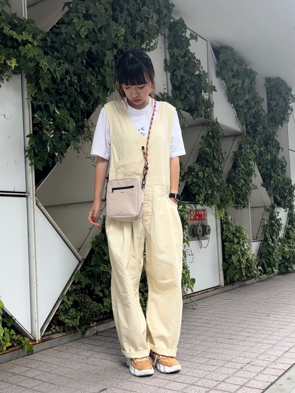 ベージュ系のショルダーバッグ、ベージュ系のスニーカー、ベージュ系のサロペット/オーバーオールを着用したレディースの夏コーディネートの2枚目の写真