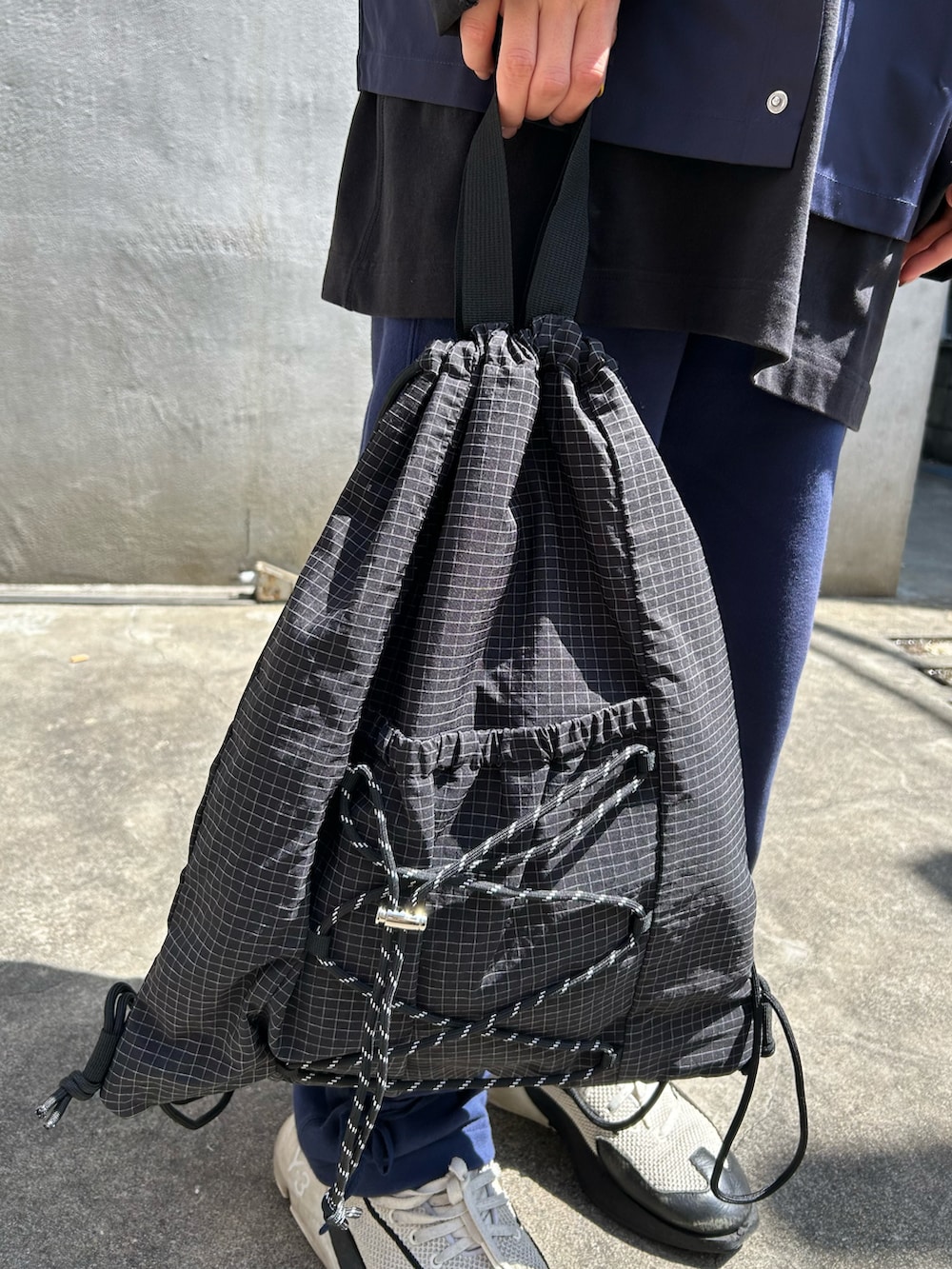 ブルー系のシャツ/ブラウス、ブラック系のバックパック/リュック、ブルー系のスウェットパンツを着用したレディースの春コーディネートの3枚目の写真