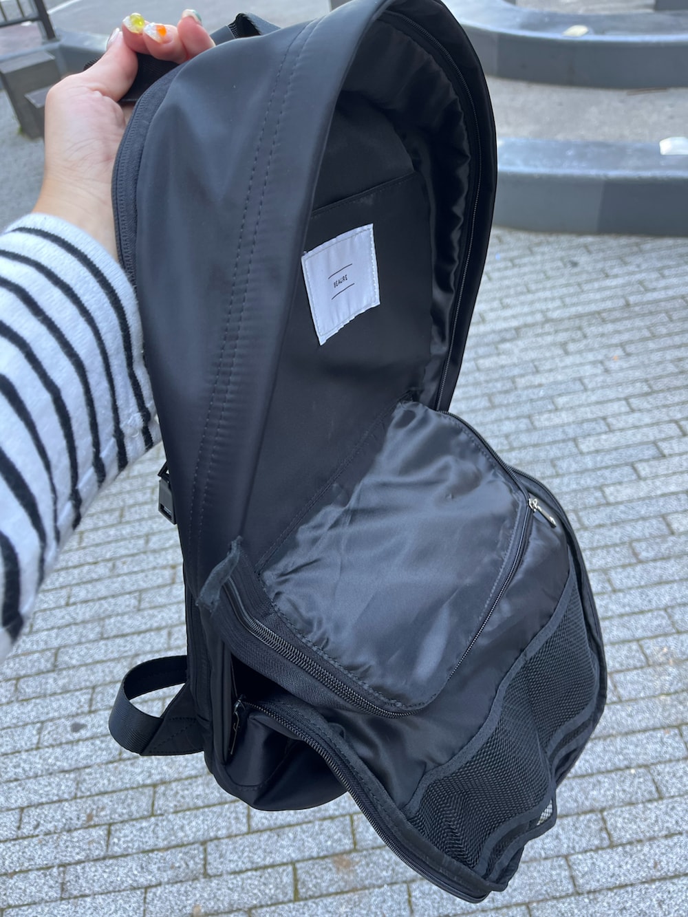 ブラック系のバックパック/リュック、ホワイト系のスニーカー、その他のTシャツ/カットソーを着用したレディースの秋コーディネートの3枚目の写真