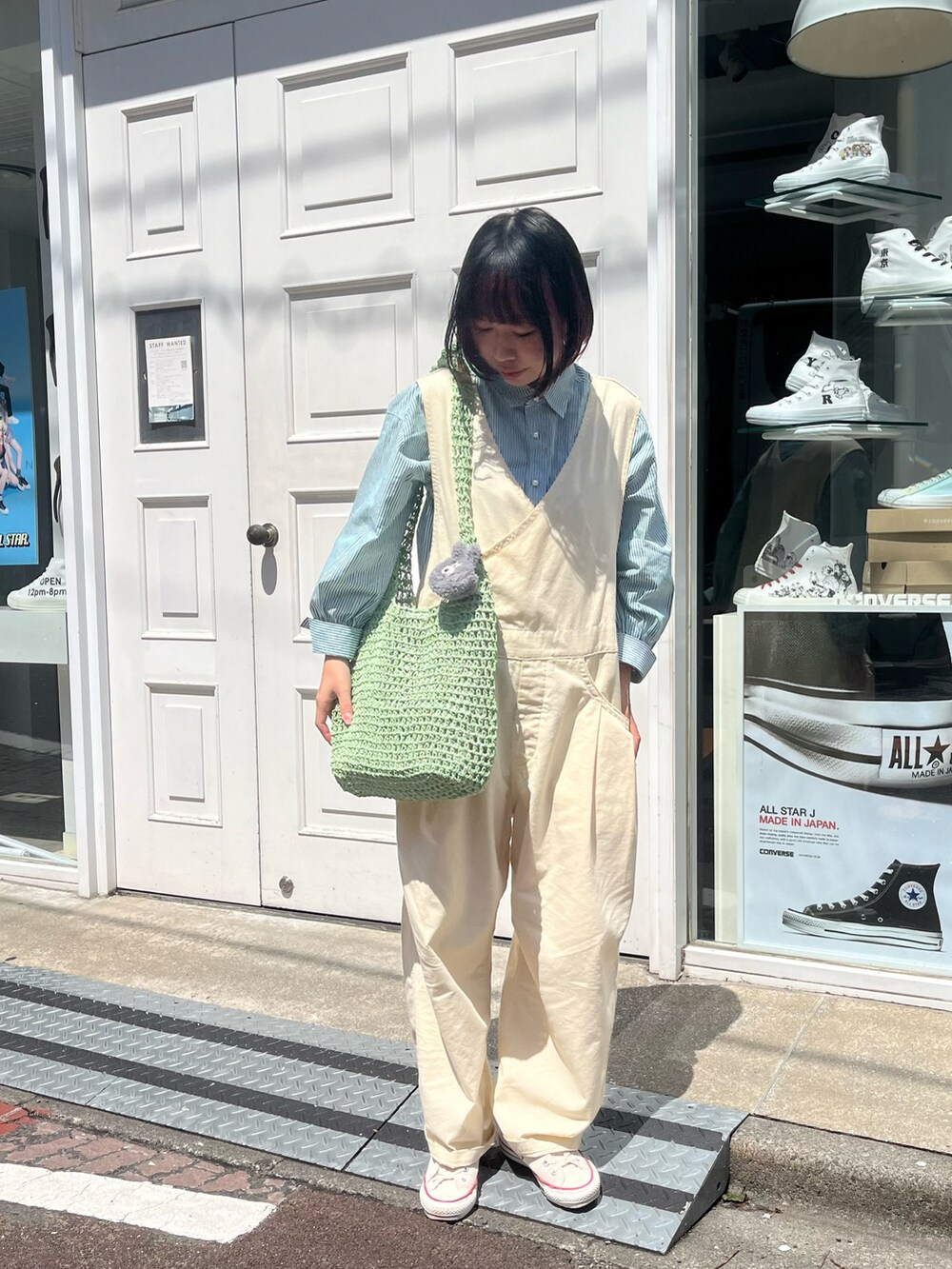 グリーン系のショルダーバッグ、グリーン系のシャツ/ブラウス、グレー系のヘッドフォン/イヤホンを着用したレディースの春コーディネートの2枚目の写真