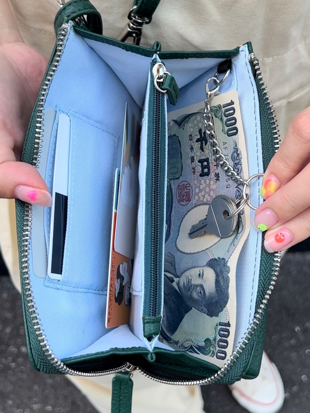 ベージュ系のオールインワン・サロペット、グリーン系のショルダーバッグ、ホワイト系のスニーカーを着用したレディースの夏コーディネートの2枚目の写真