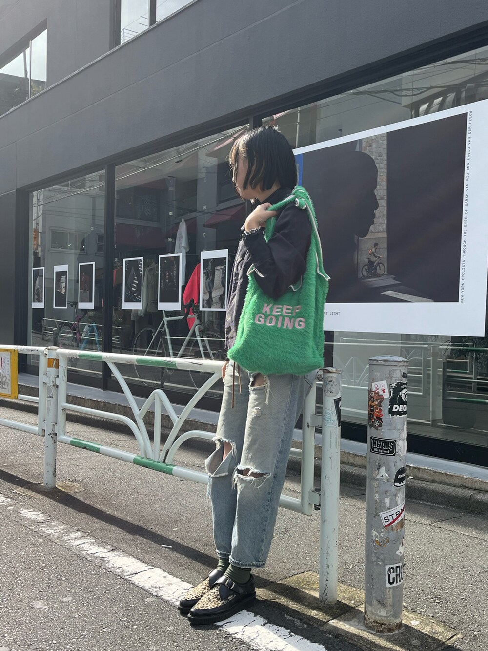 グリーン系のトートバッグ、ブルー系のデニムパンツ、グリーン系のソックス/靴下を着用したレディースの秋コーディネートの2枚目の写真