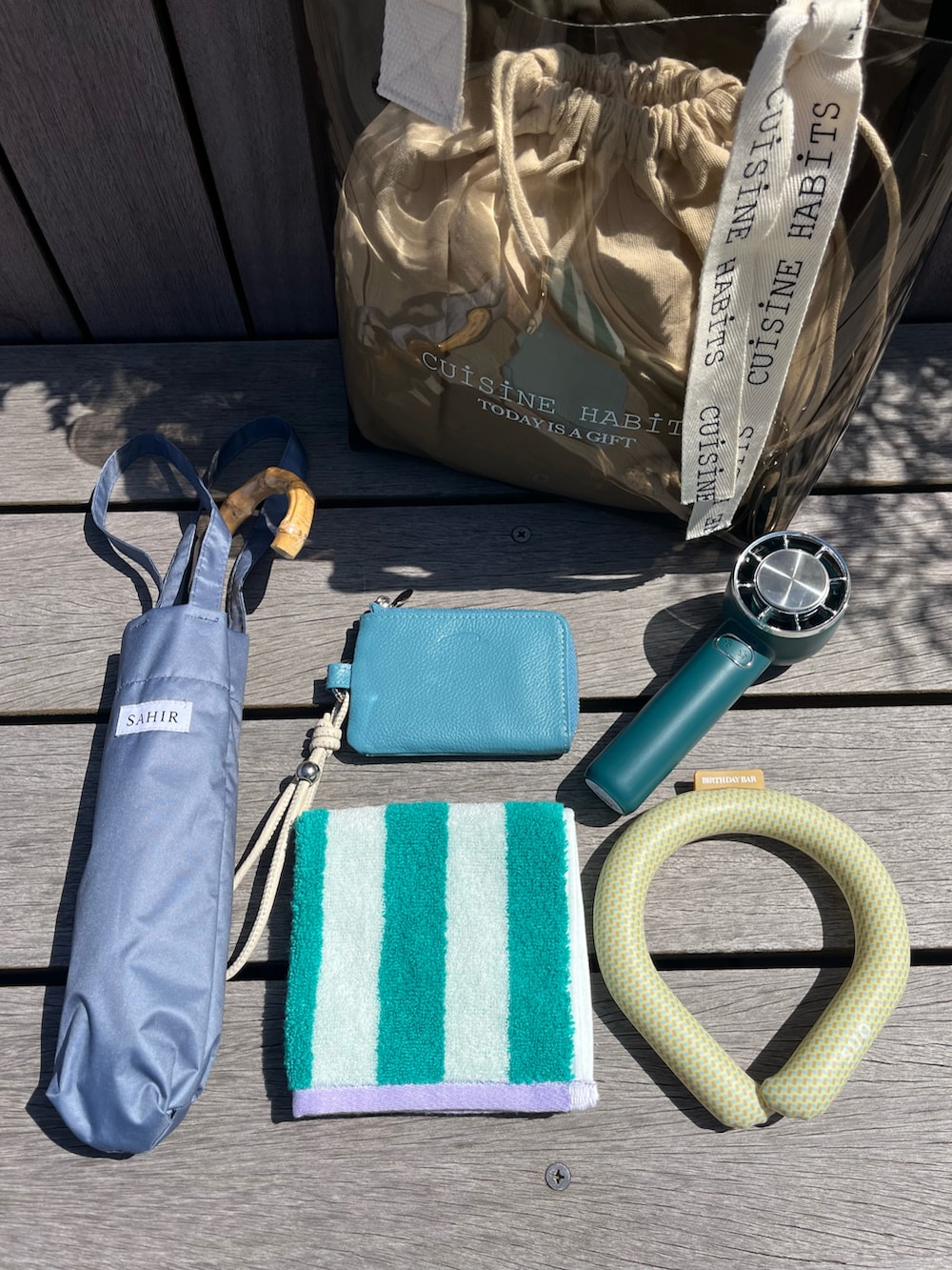 ブラック系のトートバッグ、ブルー系の財布、ブルー系の長傘を着用したレディースの春コーディネートの2枚目の写真