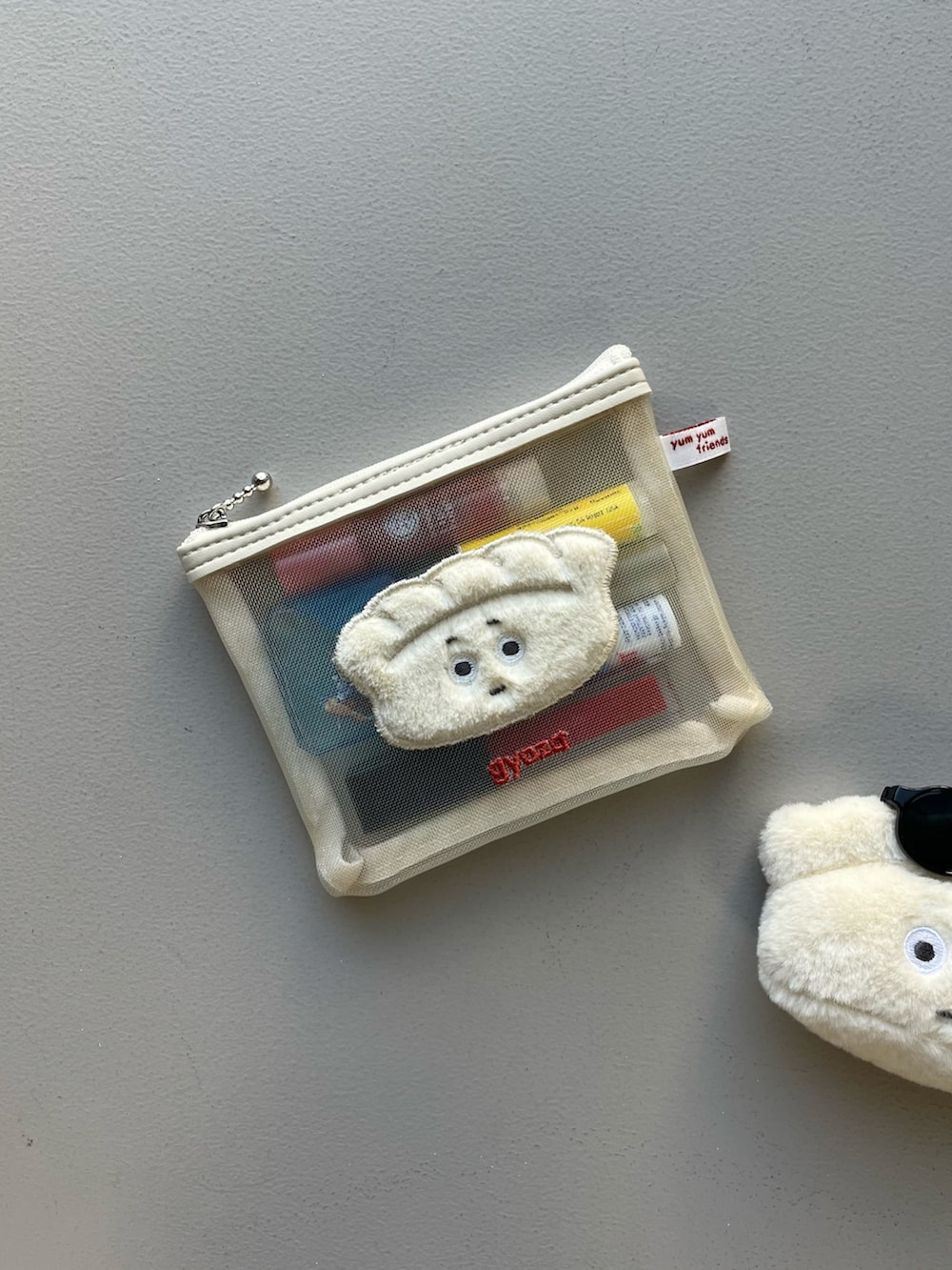 グレー系のポーチ、シルバー系のポーチ、パープル系の香水を着用したレディースの春コーディネートの2枚目の写真