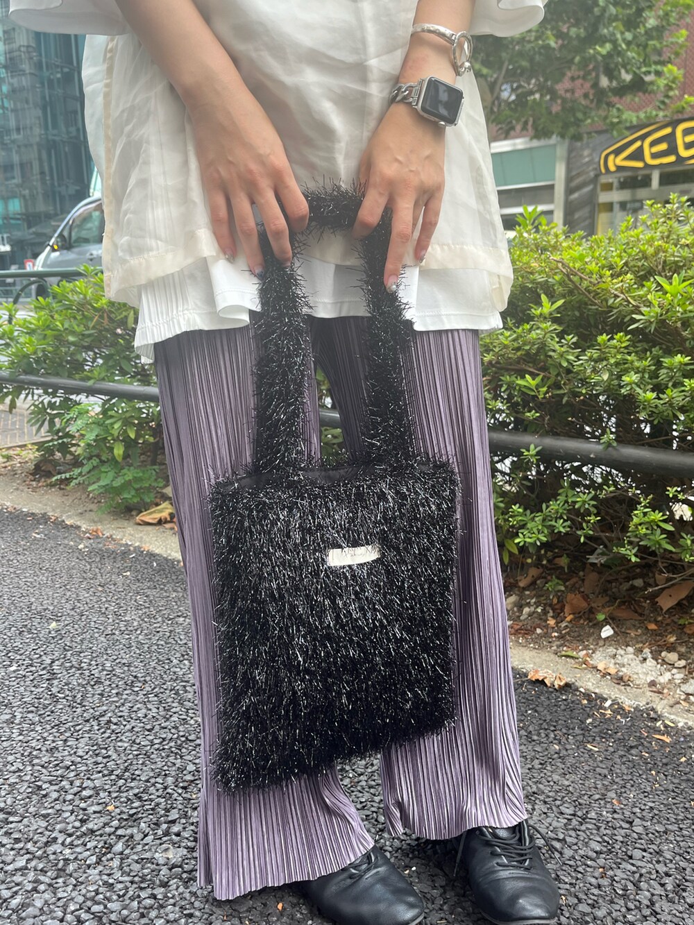 ブラック系のドレスシューズ、ブラック系のトートバッグ、パープル系のパンツを着用したレディースの夏コーディネートの2枚目の写真