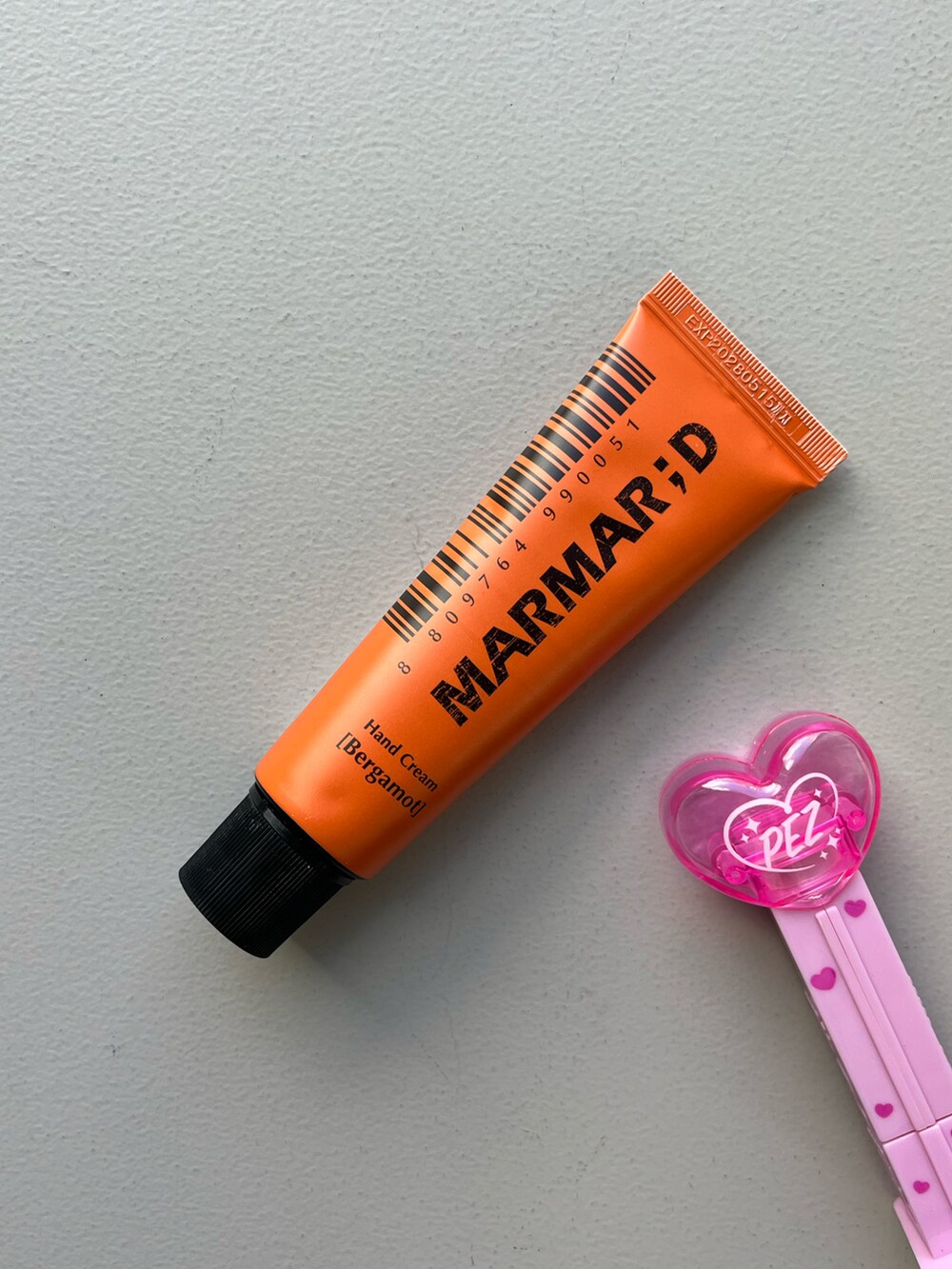 シルバー系のチャーム、ベージュ系の財布、グリーン系のポーチを着用したレディースの秋コーディネートの5枚目の写真